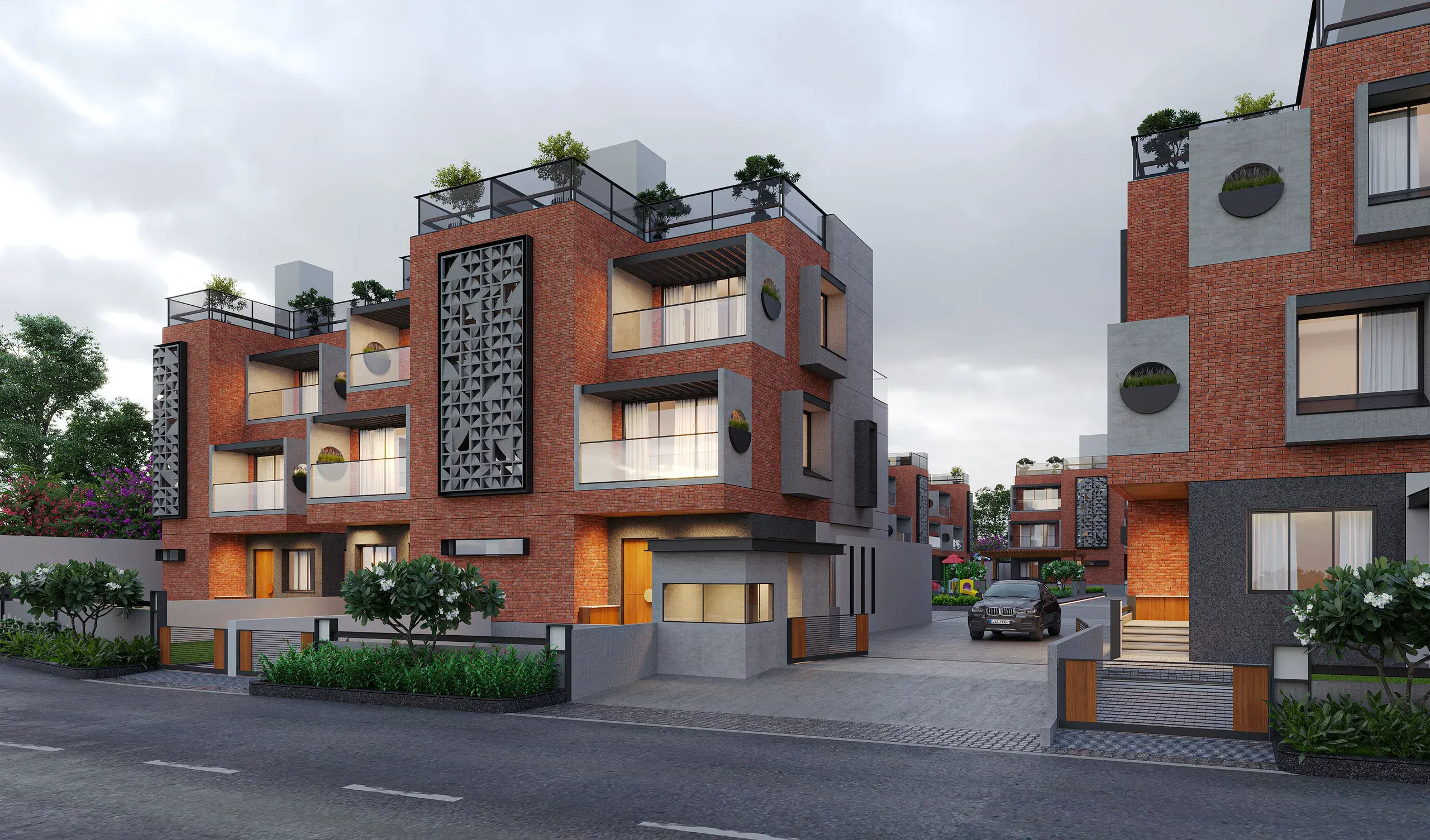 Pramukh Calista brick-faced residences along a gated entrance road at dusk